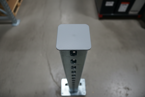 Overhead macro of powder coat gray steel post cap snapped onto silver pallet rack upright