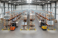 Overhead view of dual-aisle drive-thru FIFO pallet rack with entry and exit forklifts on opposite sides